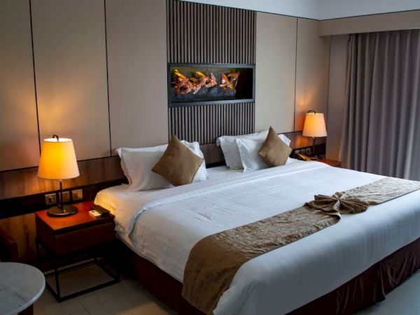 A neatly arranged hotel room with a large bed, brown accents, and warm lighting from bedside lamps, creating a cozy atmosphere.